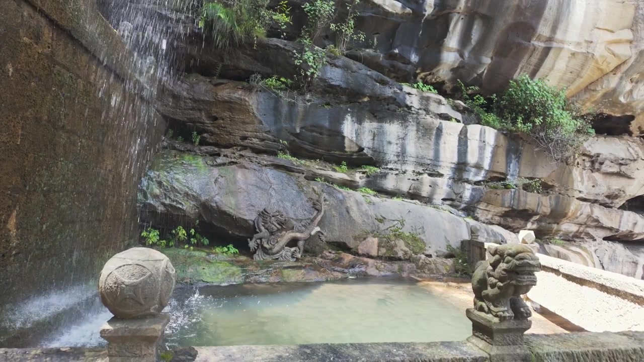 Un temple de pierre ancien et serein avec une cascade naturelle se jetant dans un bassin sacré, orné de sculptures traditionnelles de dragons et de lions.
