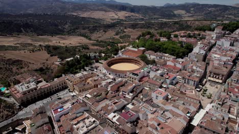 Toma-Panorámica-Aérea-De-La-Plaza-De-Toros-Y-El-Puente-Del-Desfiladero-Del-Tajo-En-Ronda,-Andalucía,-España