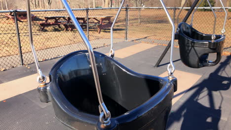 empty toddler swing set in park, winter time