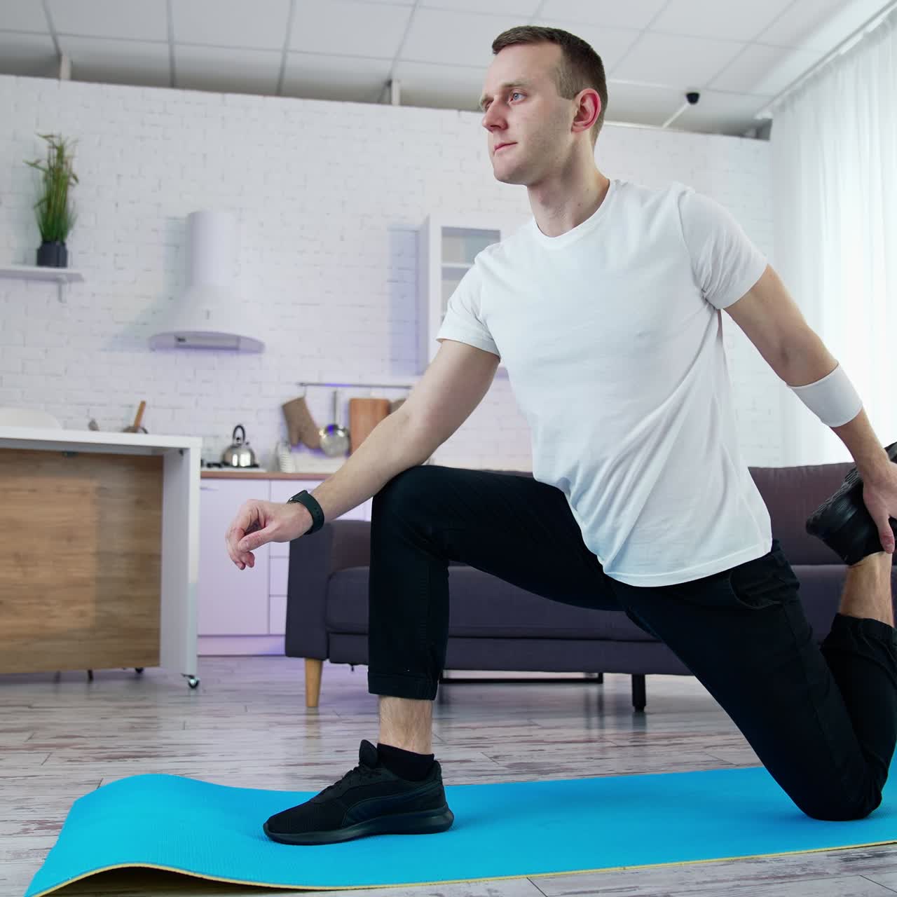 Strong athletic active person working out indoor. Handsome healthy man training his body in home