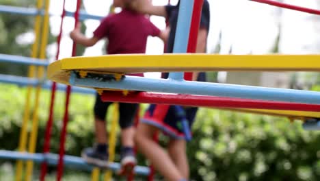 carrusel de patio de recreo girando con niños en el fondo subiendo a la barra de monos