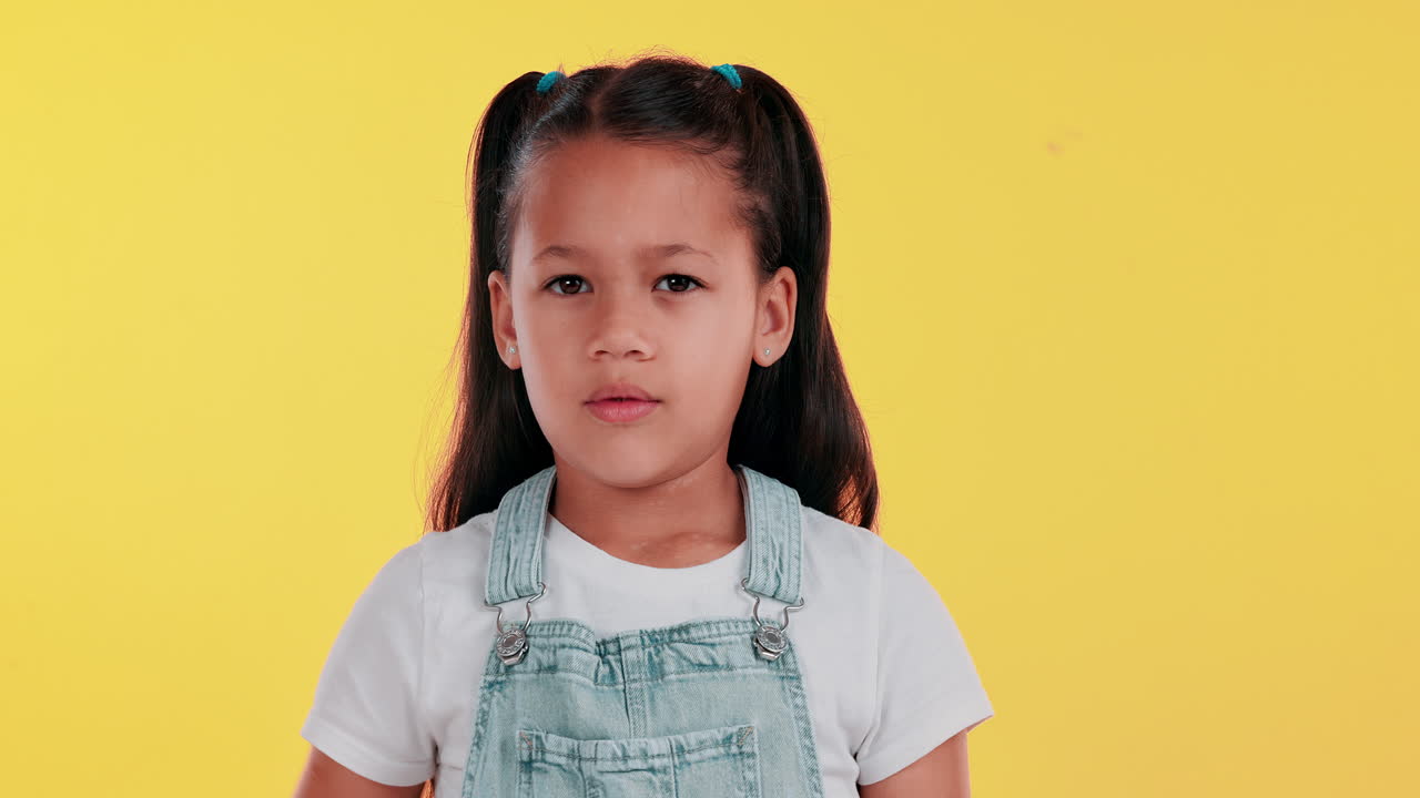 A young girl with her hand up in a stop gesture
