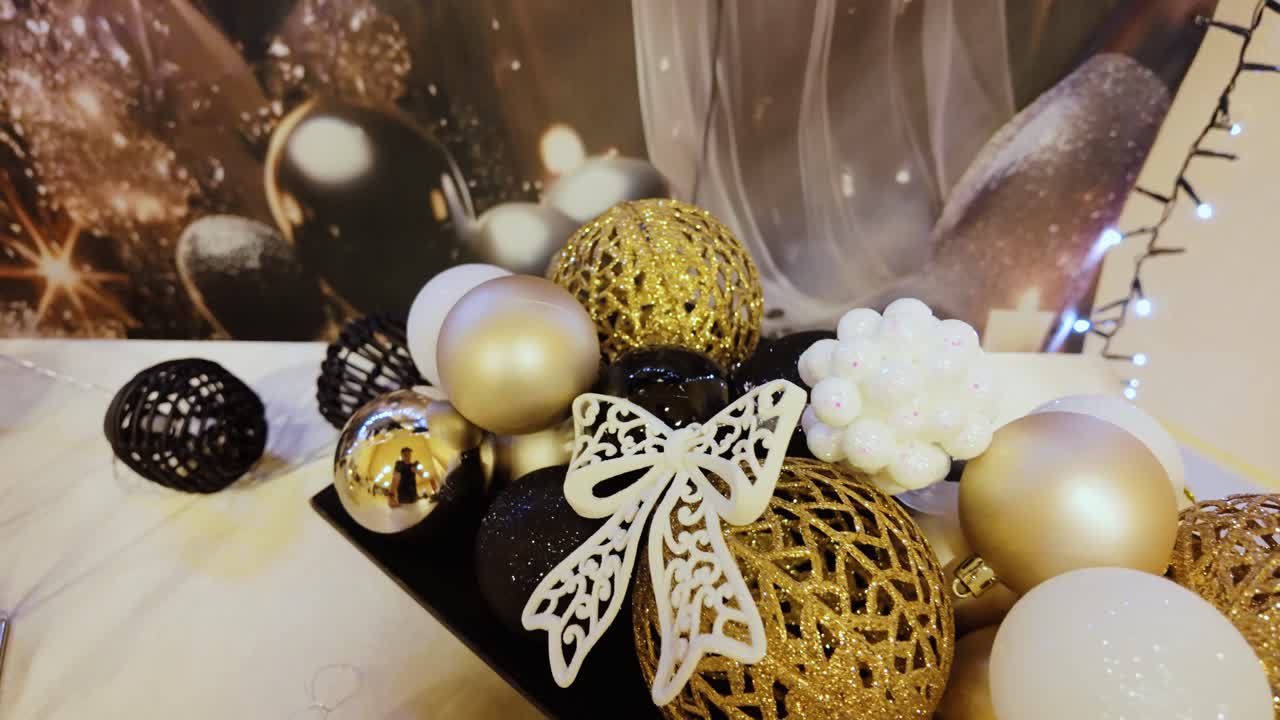 Enfeites festivos e estilosos em tons de dourado, branco e preto brilhando sob as luzes