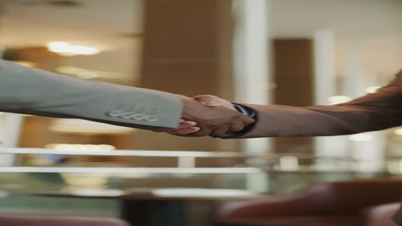 Primo piano di stretta di mano tra professionisti d'affari nella lobby dell'hotel