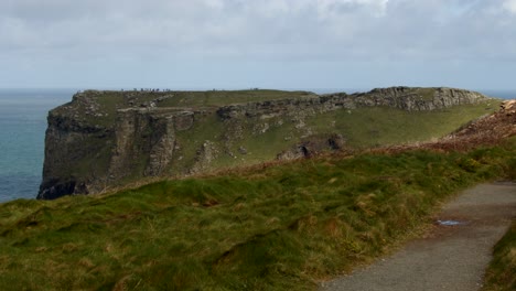 Toma-Extra-Amplia-De-Los-Acantilados-De-Tintagel-Con-El-Sendero-Costero-En-Primer-Plano,-Desde-La-Tregatta-Penhálica-Inferior