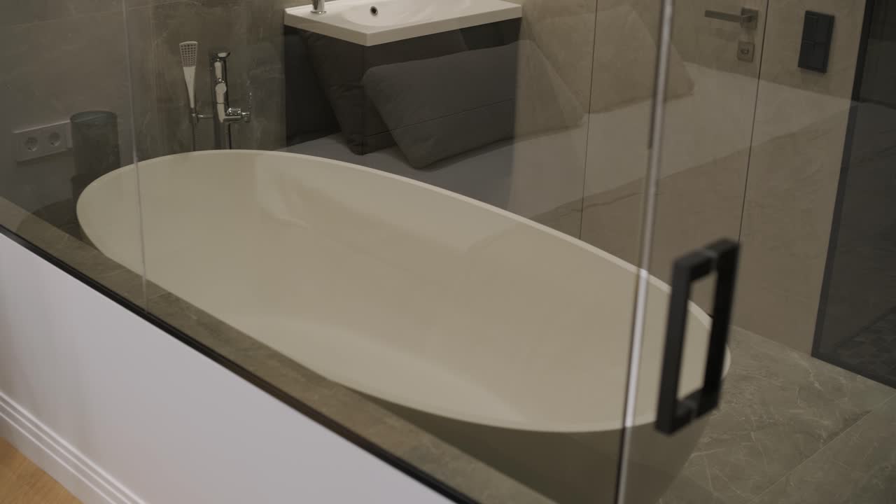 현대적인 침실 디자인으로 가죽으로 된 헤드보드, 파란 불이 있는 나이트 스테이크, 그리고 유리 벽을 통해 볼 수 있는 객실 화장실