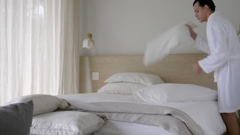 Man-In-Robe-Fixing-His-Bed-After-Shower-In-The-Morning