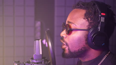hombre cantando en un micrófono en un estudio de grabación