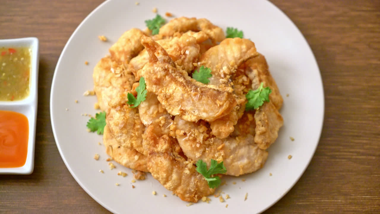 접시에 마늘과 튀긴 생선