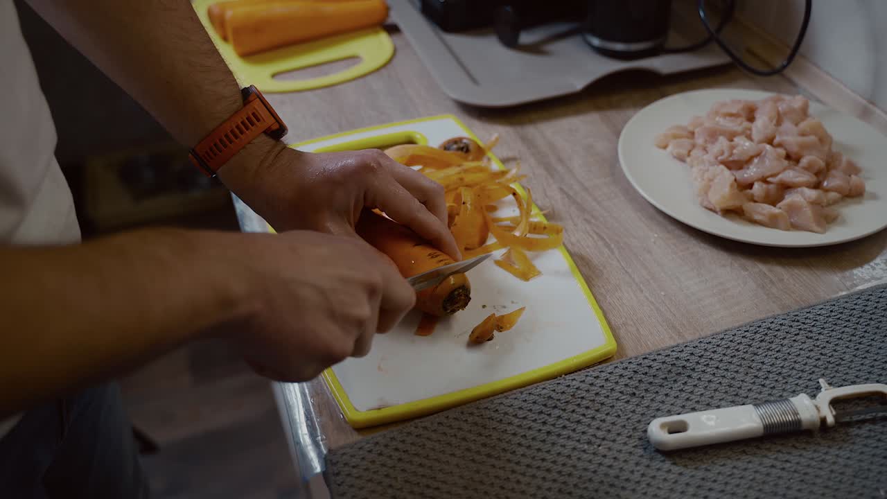 hombre cortando verduras a mano. vista de cerca de un hombre cortando zanahorias a mano en la tabla de cortar. nutrición orgánica. preparar una comida sabrosa. cocina de alimentos y concepto de personas. cocina de comida saludable en casa.
