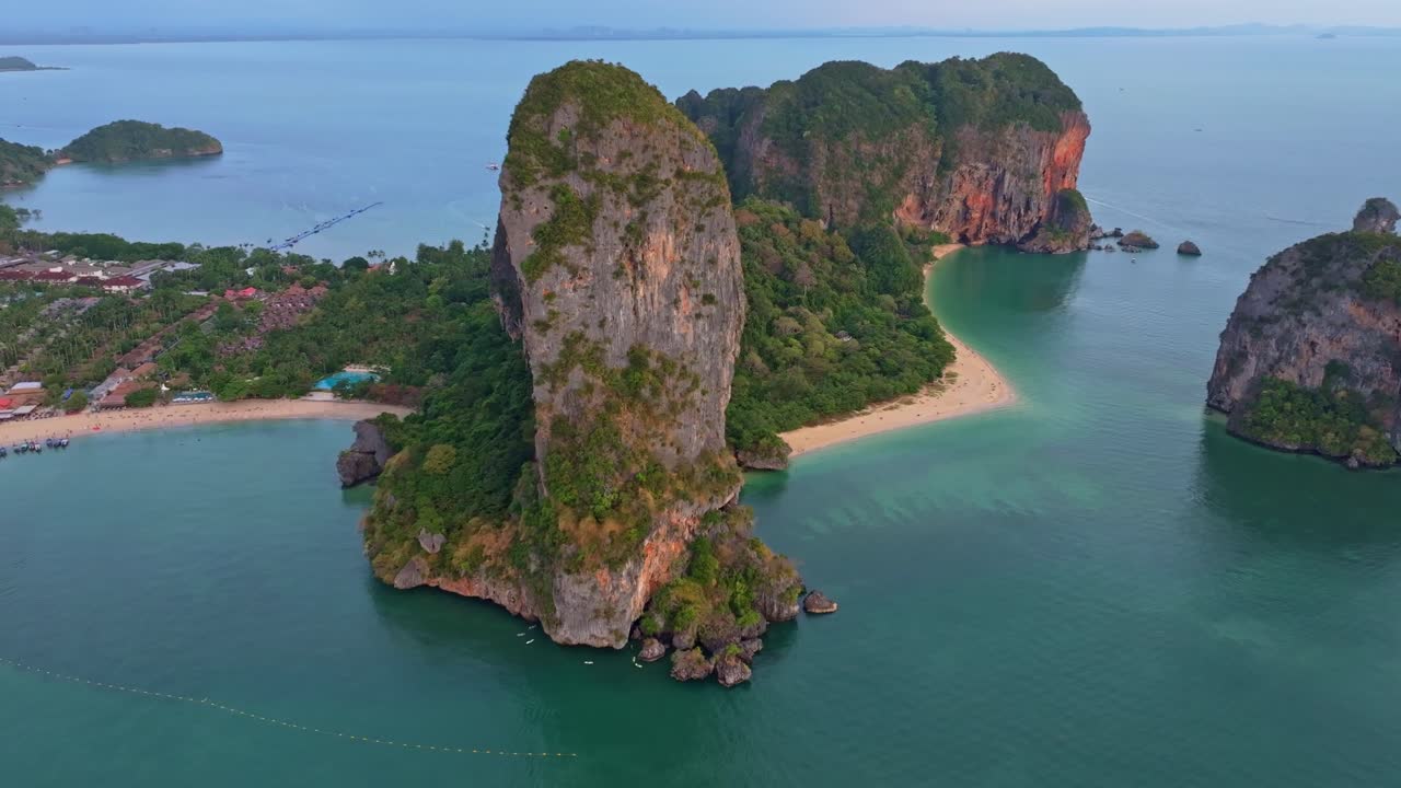 Bãi biển Railay sáng rực khi những chiếc thuyền lướt qua các khối đá ở Thái Lan.