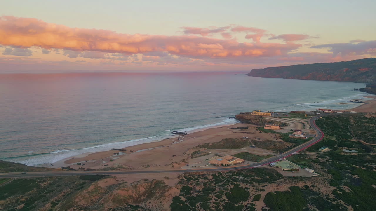 Aerial view scenic coastline as sunset casting warm glow over cliffs and beach