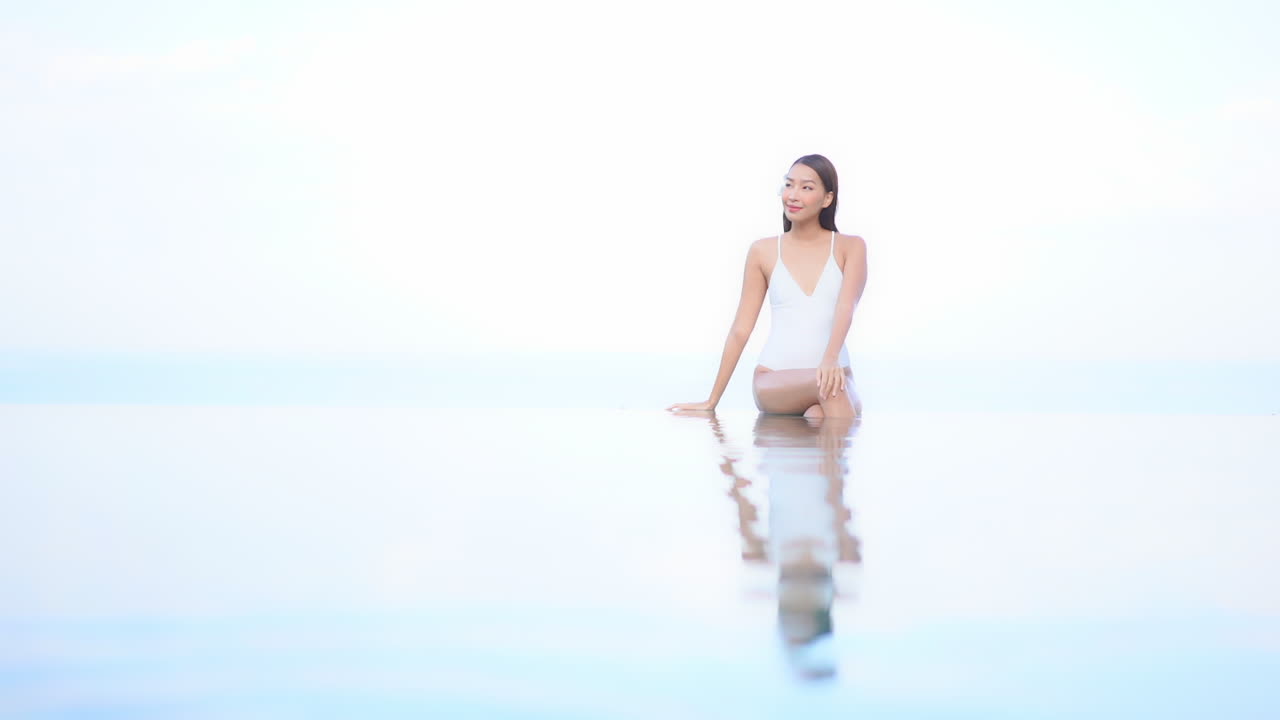 꿈꾸는 듯한 열대 휴가, 수영복을 입은 여성, 하늘과 합쳐지는 인피니티 풀의 머리카락에 꽃