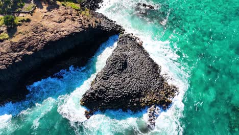 hexagonal rock formations meet turquoise ocean waves