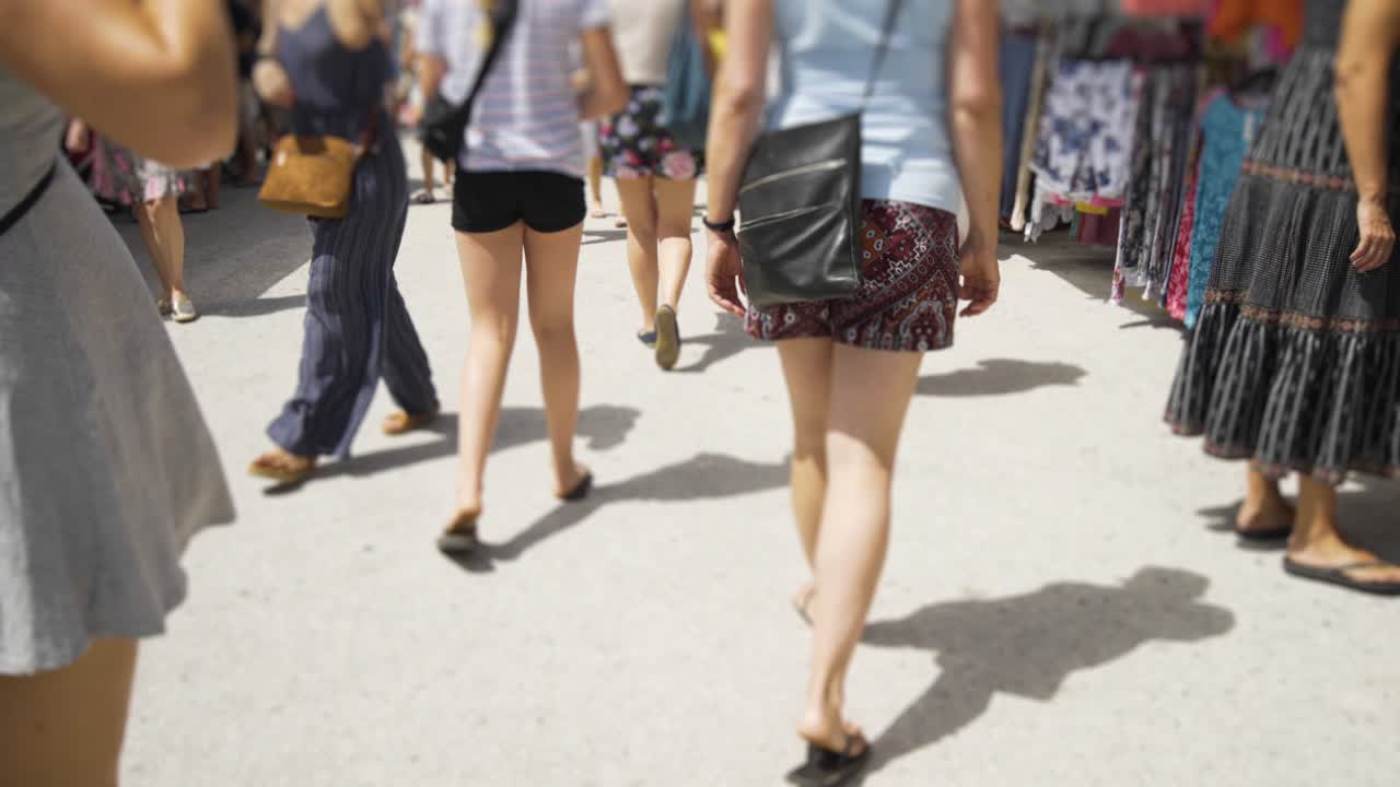 Walking down between the market stalls of Cala De Mijas on the Costa Del Sol in Southern Spain. A gradient blur filter subtly hides the faces of the shoppers