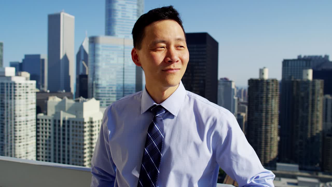 empresario americano asiático en el techo con vistas al paisaje urbano de chicago