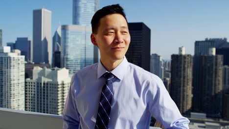 asian american businessman on rooftop overlooking cityscape chicago