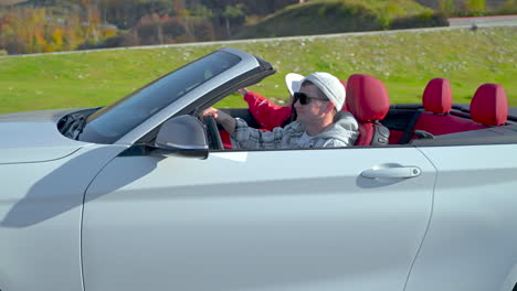 man driving a white convertible car