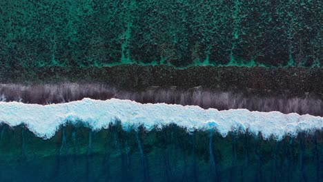 aerial view of waves crashing on a coral reef