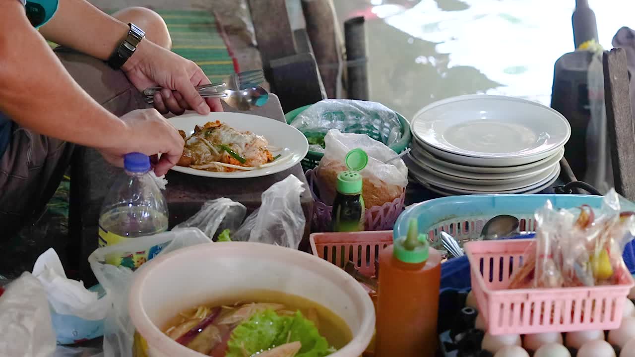 Vendor prepares crispy mussel pancakes in Bangkok market