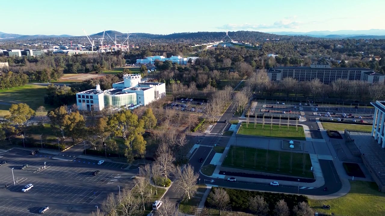 Paesaggio aereo ripreso da drone dell'edificio del Questacon National Science and Technology Centre con il Parlamento Australiano sullo sfondo a Parkes, vicino al lago Burley Griffin, città di Canberra, turismo dell'ACT.