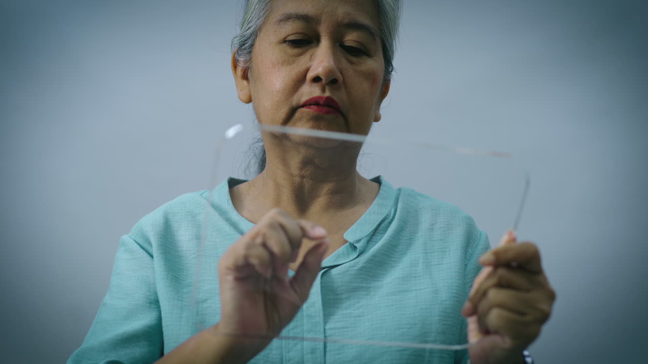 미래 지향적인 투명 터치스크린 패드를 사용하는 아시아 활동적인 노인 여성의 하이테크 개념