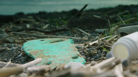 close up shallow focus shot of a flip flop and other washed up plastic on the beach