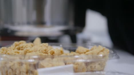 side shot of woman's hand while taking trahana pieces to cook a traditional mediterranean soup