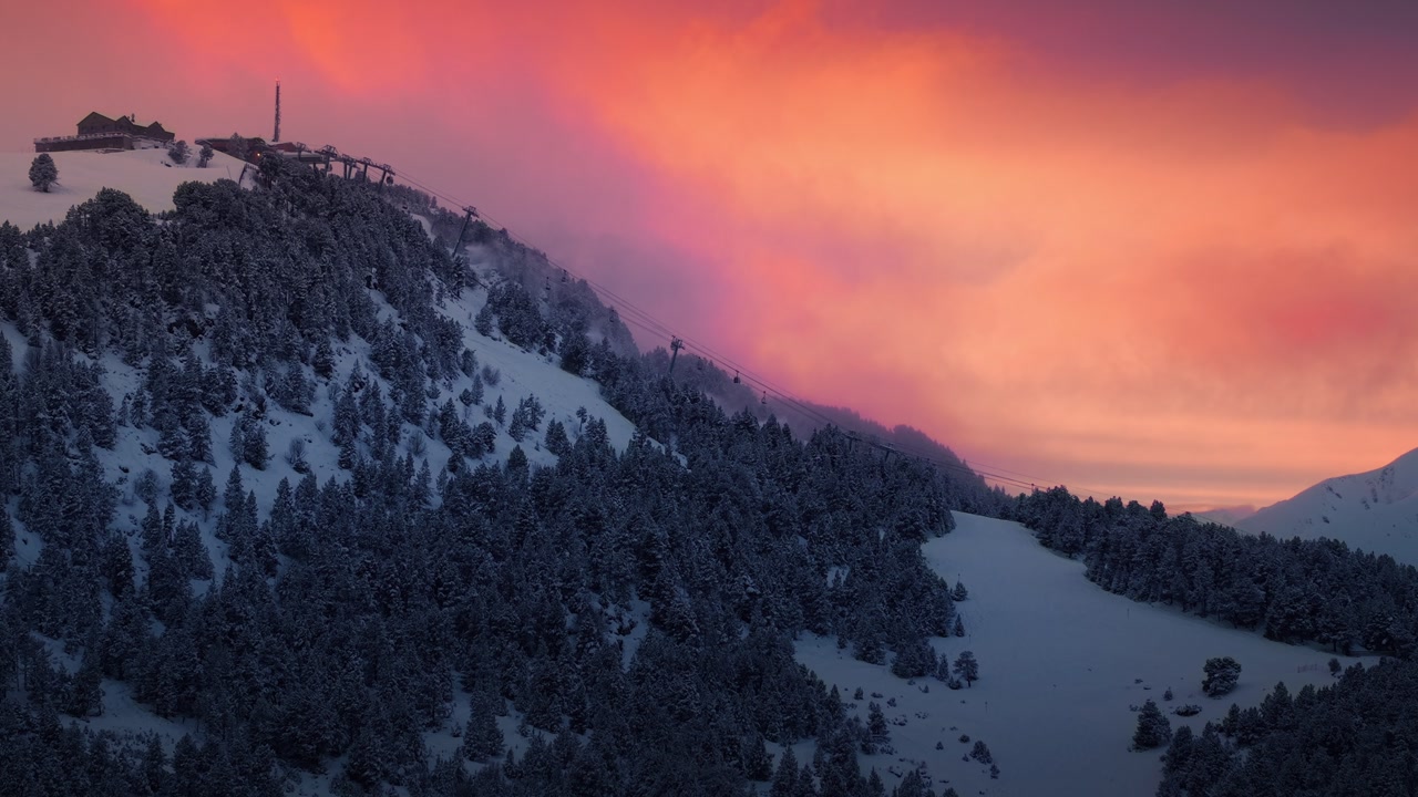 Drone flies toward ski resort in Andorra with chairlifts and vibrant sunset sky
