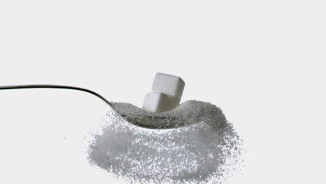 sugar cubes falling onto spoon full of sugar