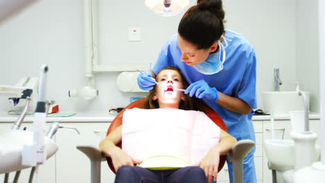 Dentist-examining-a-young-patient-with-tools