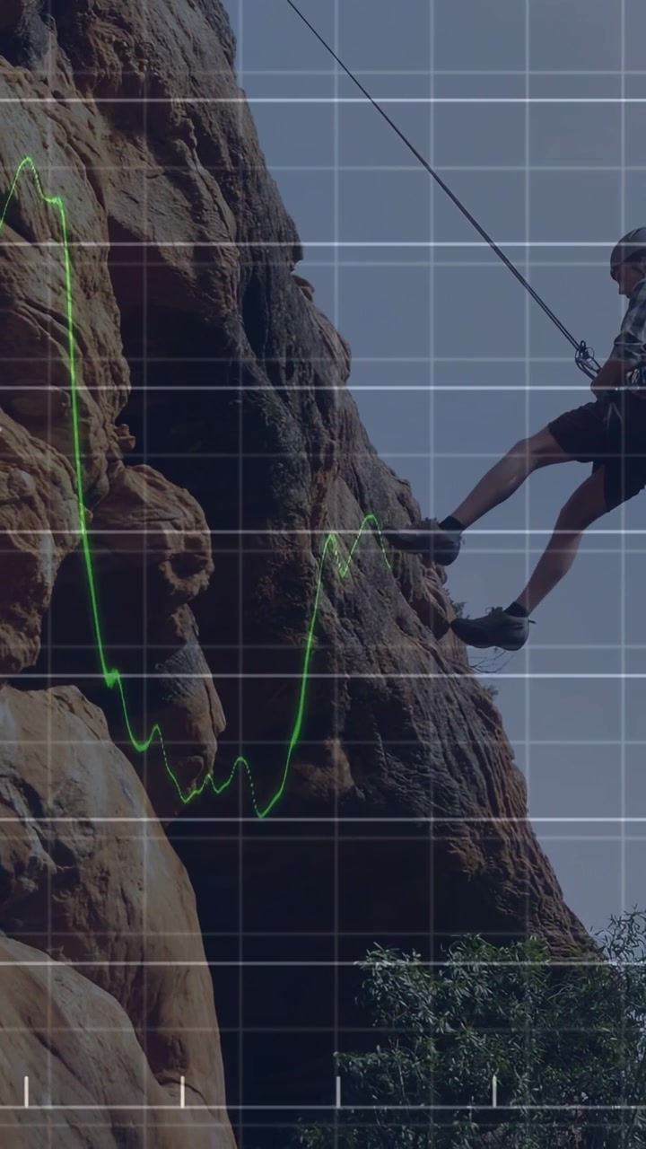 Video vertical: Escalador tirando de una cuerda, descendiendo a la base de un acantilado, con gráficos financieros superpuestos.
