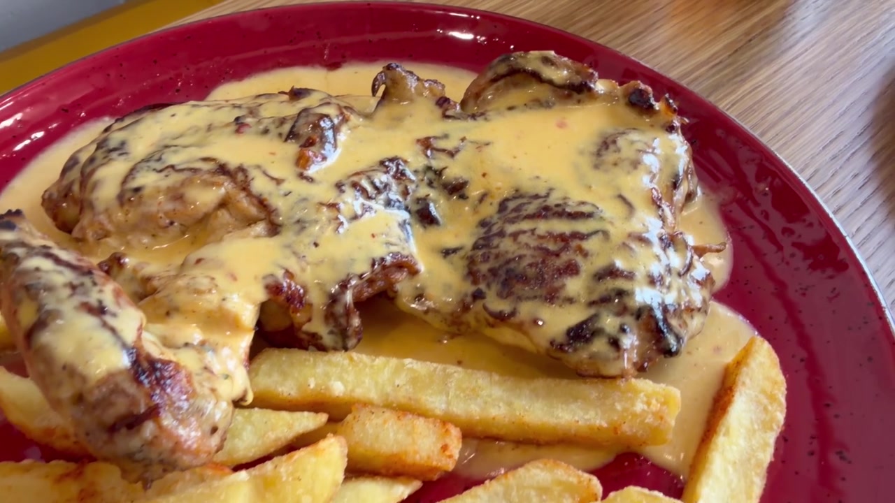 Peri peri chicken and chips served in a restaurant on a hot plate.