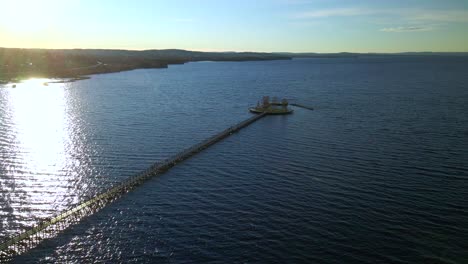 Sunbeam-on-Water,-Footbridge-at-Sea,-Tranquil-Concept,-Aerial