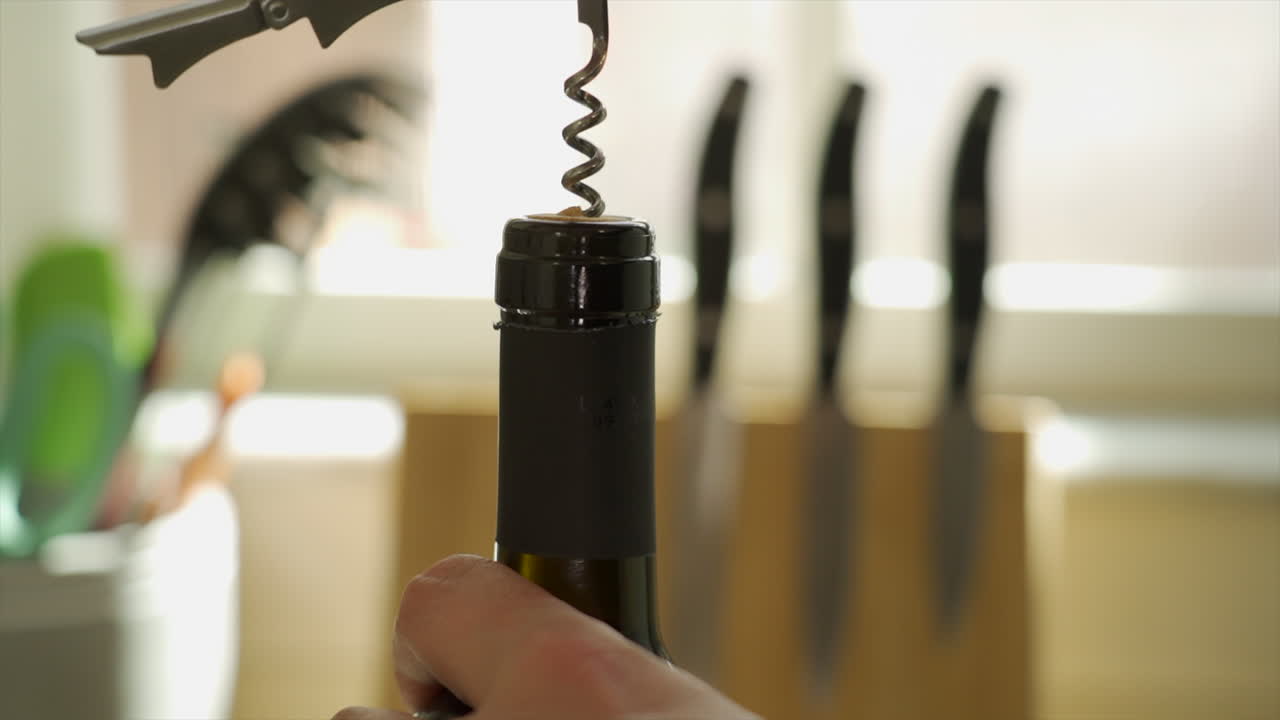 manos torciendo el abrebotellas