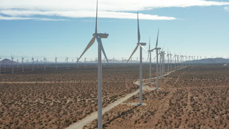 camera jibs up displaying a vanishing row of windmills at a solar farm