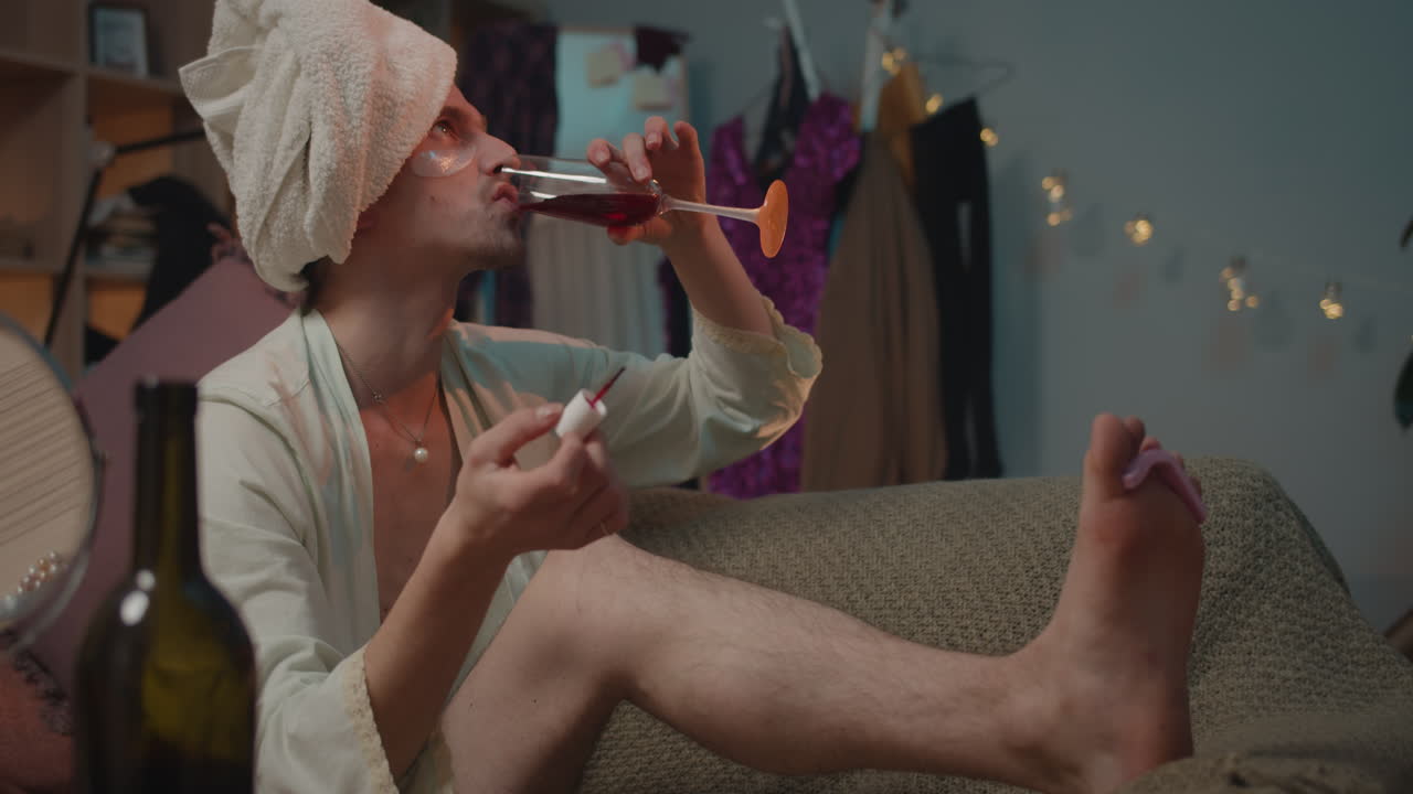 Man Painting Toenails and Drinking Wine