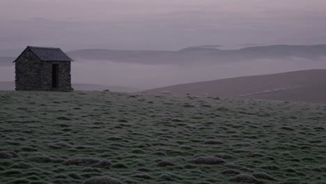 misty mountain landscape with stone hut and sheep