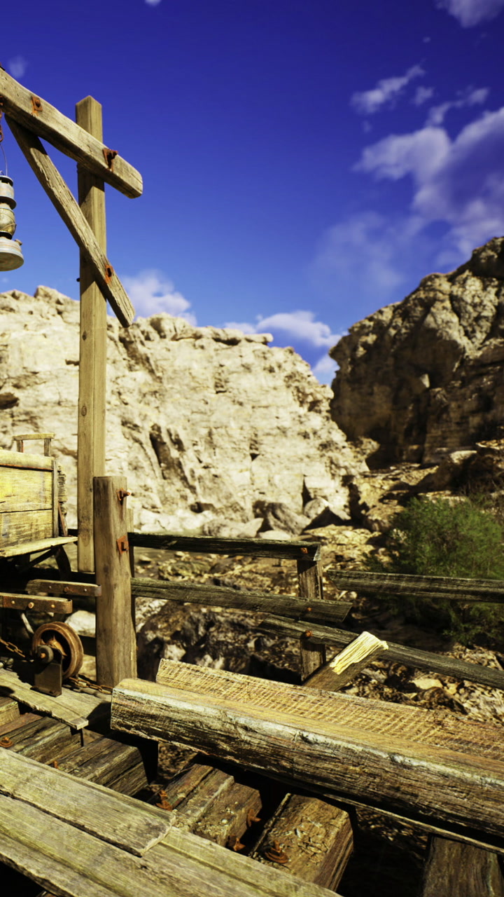 Rustic wooden structures in a vast desert landscape under a bright sky
