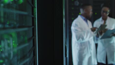 African-american-male-computer-technicians-using-tablet-working-in-business-server-room