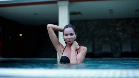 woman in a black bikini by a pool