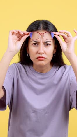 woman squinting and adjusting glasses with confused expression