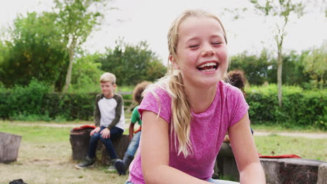 portrait of  girl on outdoor activity camping trip sitting around camp fire with friends