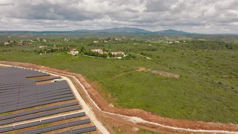 Toma-Aérea-Larga-De-Una-Granja-Solar-Y-Hermosas-Villas-En-El-Campo-Portugués,-Concepto-Para-El-Contraste-Entre-Naturaleza-Y-Tecnología,-Tradición-Y-Modernidad