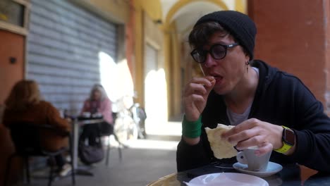 person eating bread and drinking coffee in a cafe