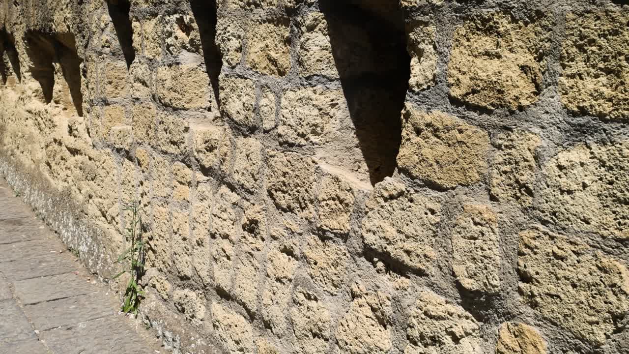 muro de piedra con aberturas triangulares en nápoles, italia