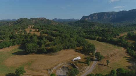 Drone-zoom-out-to-discover-concrete-road-at-Esquirol-village,-Barcelona