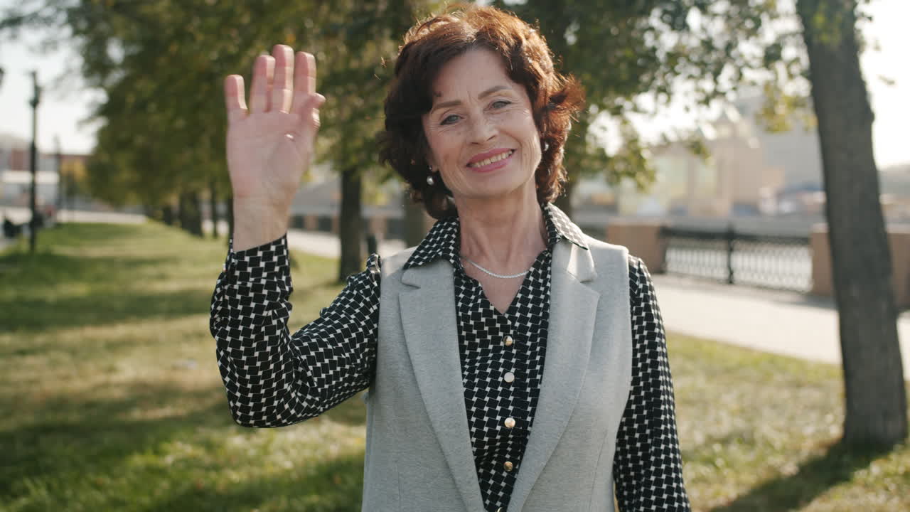 Senior Woman Waving in a Park