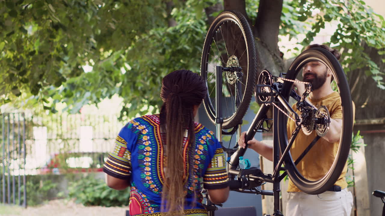 손상 된 자전거 에서 일 하는 부부