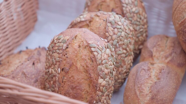 Loaves of fresh seed bread in woven basket, close up